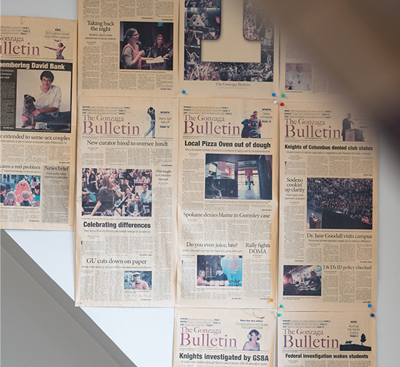 A woman stands next to several kayaks